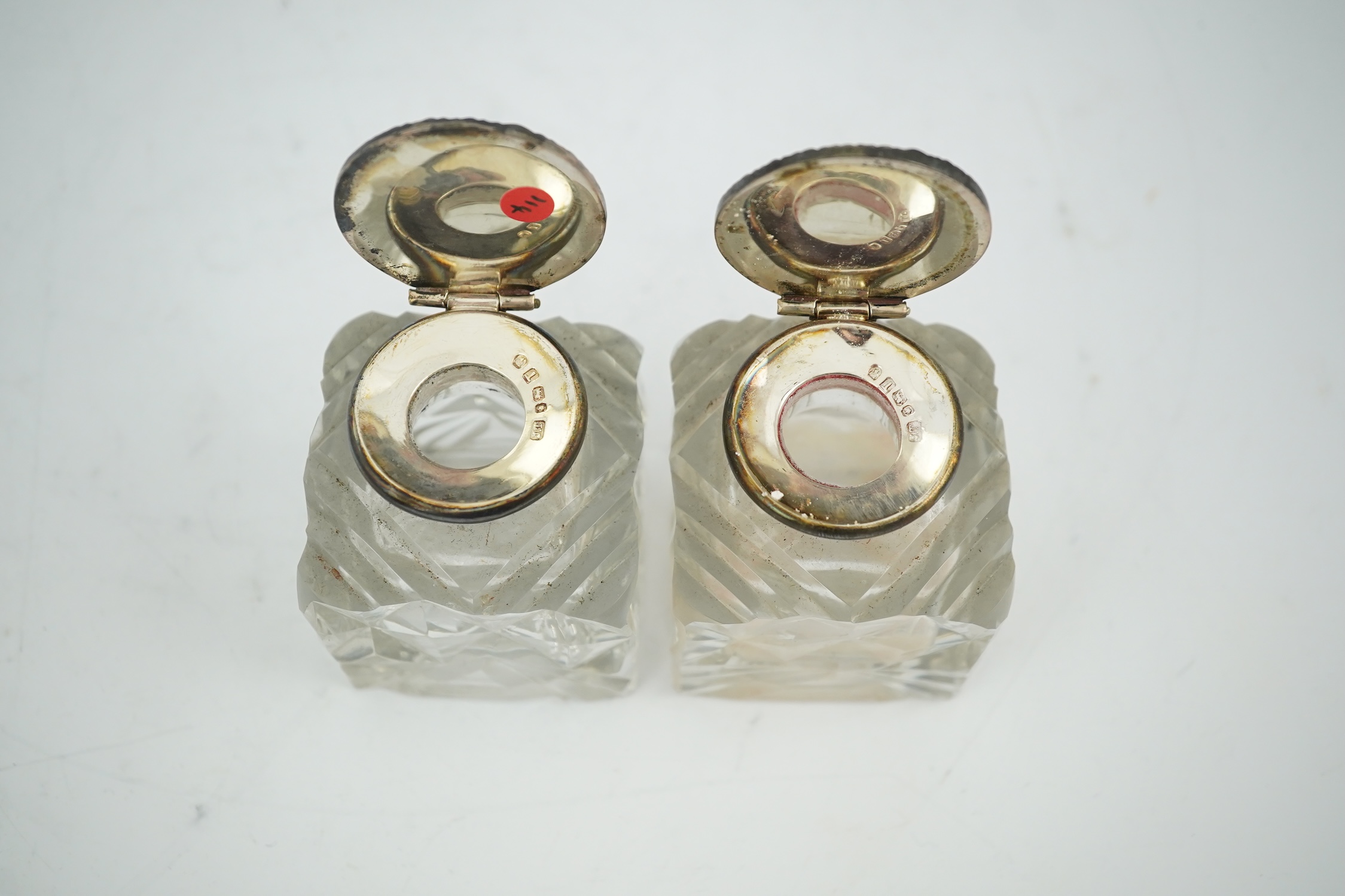 A pair of silver mounted cut glass inkwells, maker JT, height 66mm. Condition - fair to good